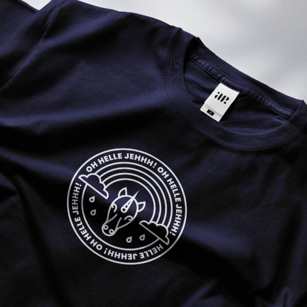Een close-up van een witte print op een donkerblauw shirt toont een cirkelvormig ontwerp met daarin een gestileerde eenhoorn.